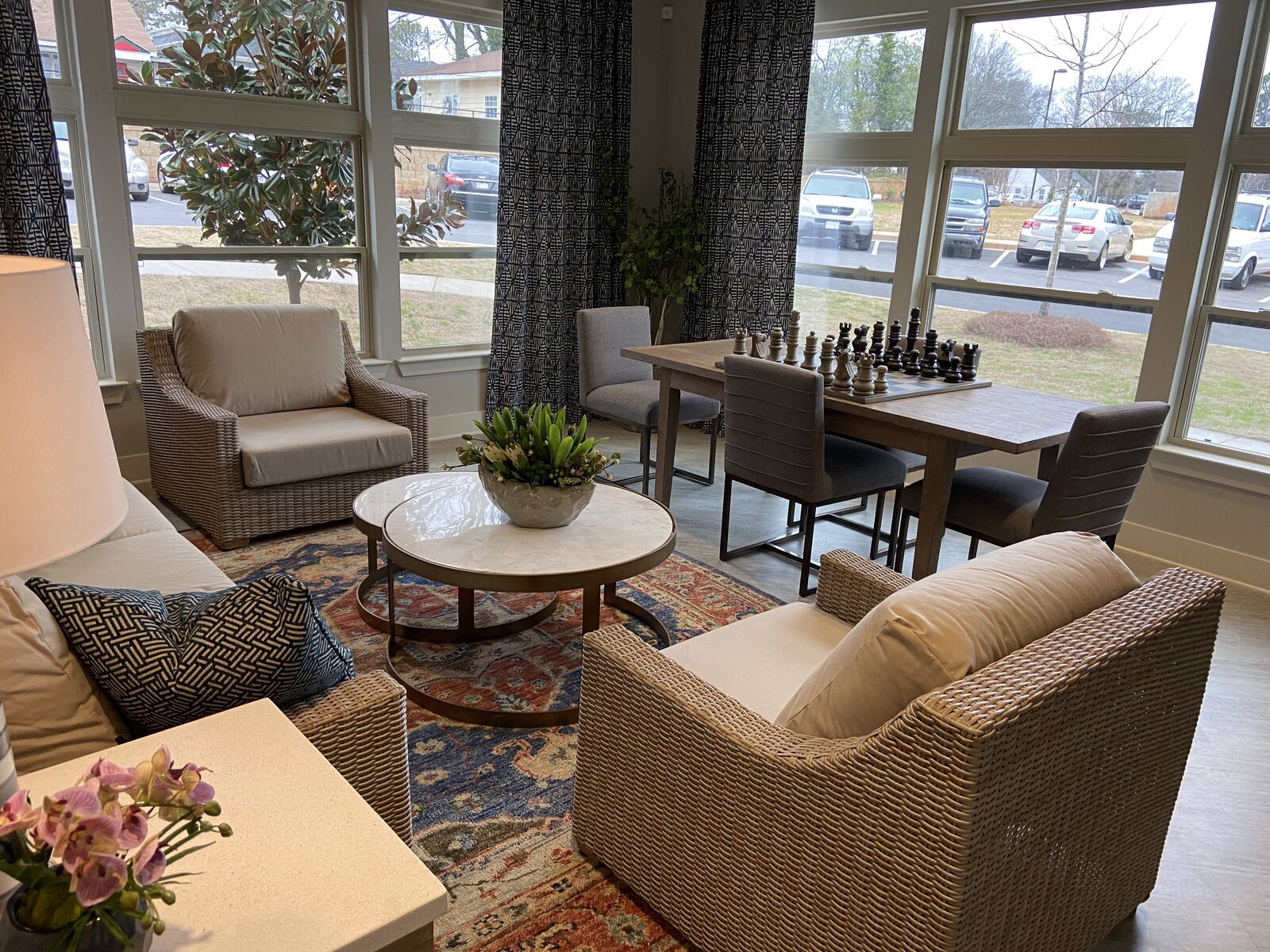 Bright sunroom lounge with armchairs, coffee table and game table