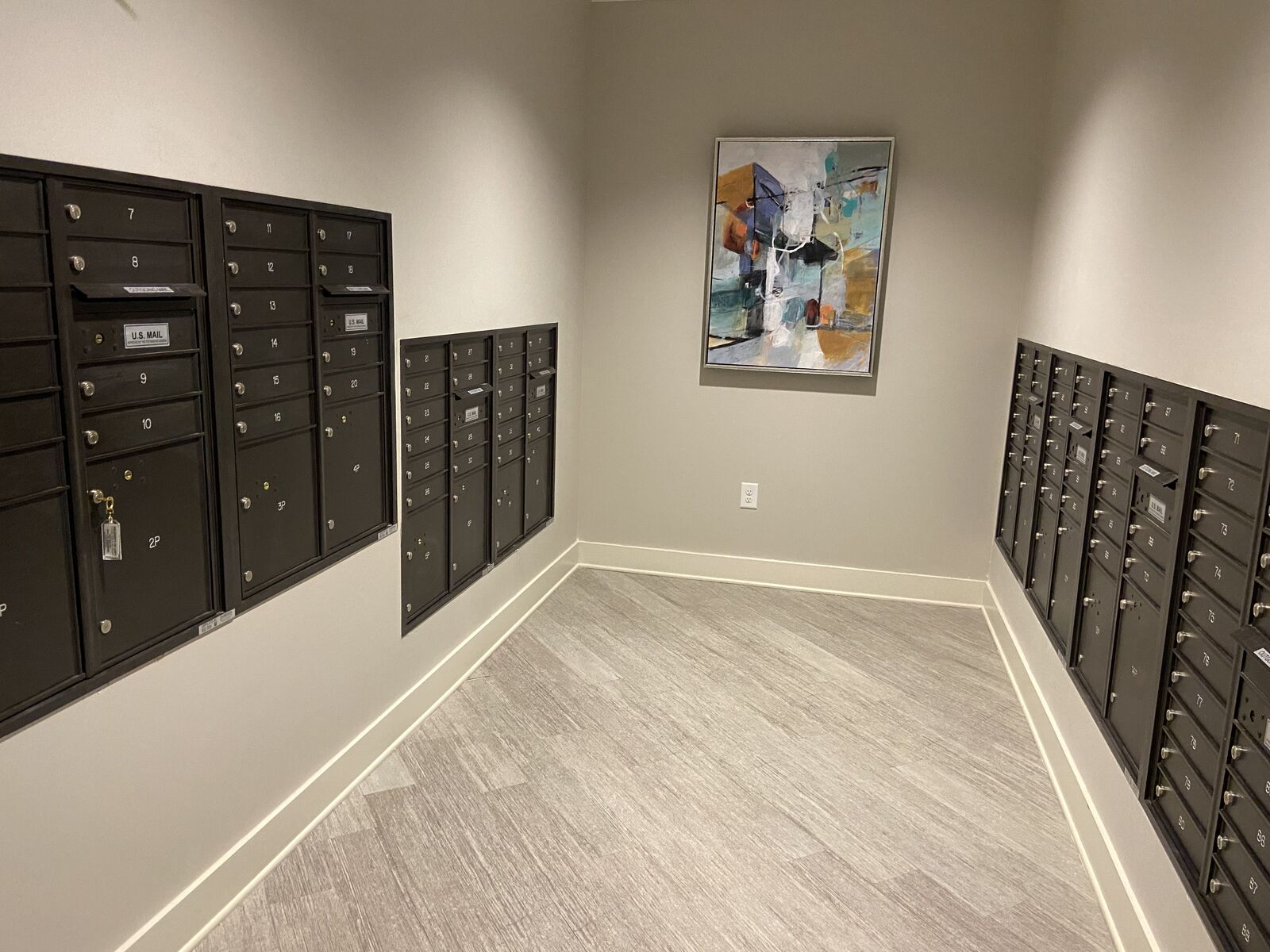 Mail room with wall-mounted mailbox units and wood-look flooring