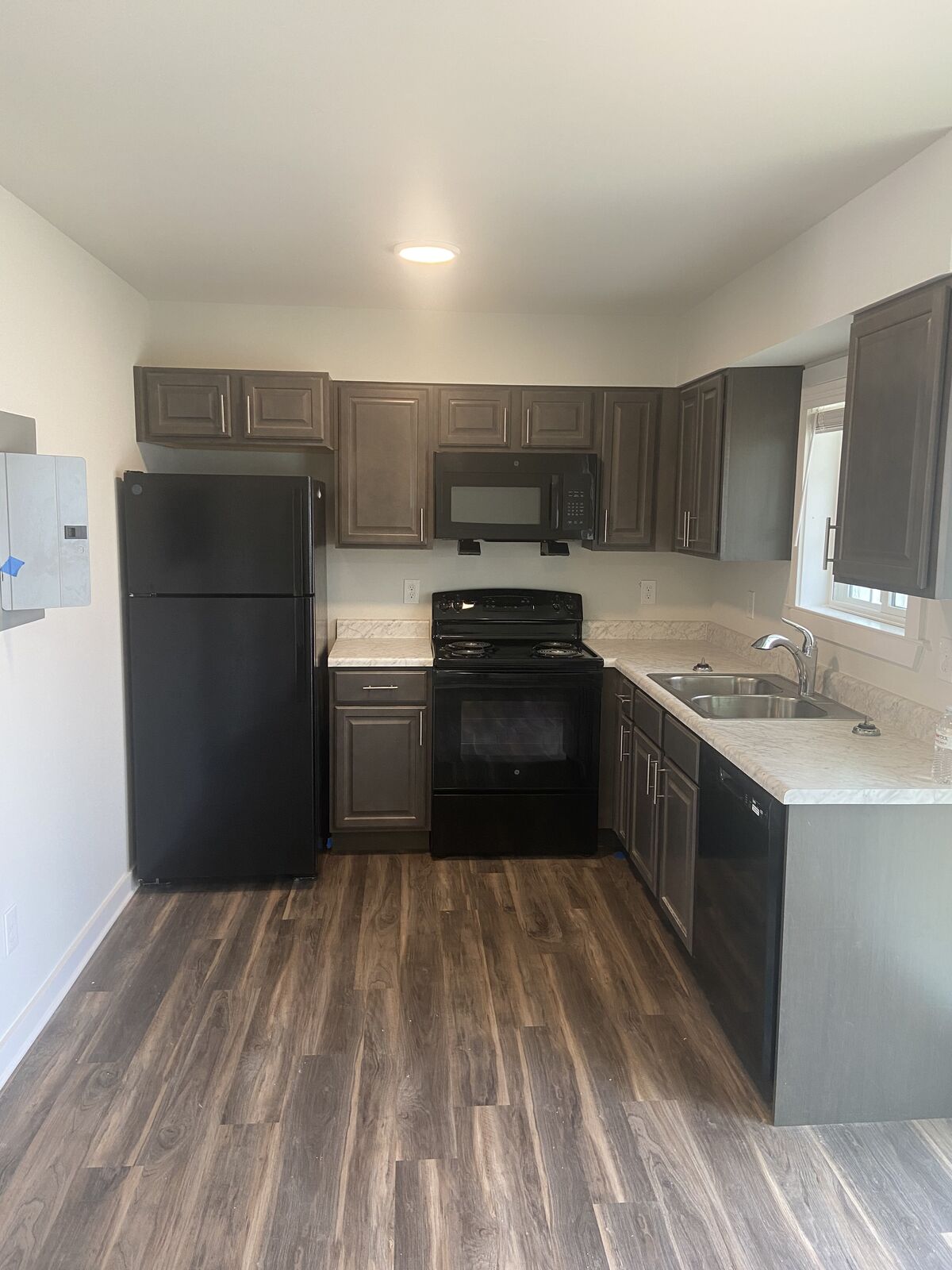 Apartment kitchen with gray cabinets and black appliances